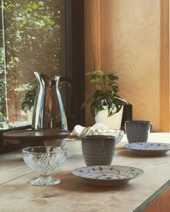 彻默岛Elevated Tiny House Glamping的一张桌子,上面有碗和盘子,上面有花瓶