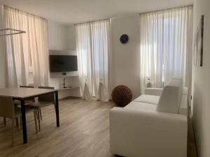 加尔达湖滨San Rocco Apartments的客厅配有白色的沙发和桌子