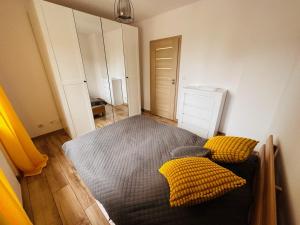 什切齐内克Apartament Neustettin-Polna Szczecinek的一间卧室配有床和两个黄色枕头