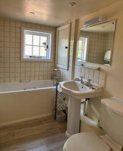 亨利昂泰晤士Gorgeous Cottage in Skirmett with Parking的带浴缸、盥洗盆和卫生间的浴室