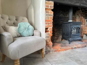 亨利昂泰晤士Gorgeous Cottage in Skirmett with Parking的壁炉前的椅子和炉灶