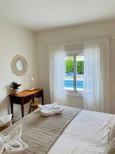 圣地亚哥港Beachfront Villa and pool的一间卧室配有一张床、一个窗口和一张书桌