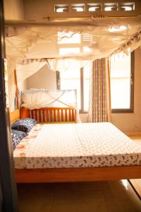 布琼布拉Ruhuka House的一间卧室配有一张天蓬床和窗户