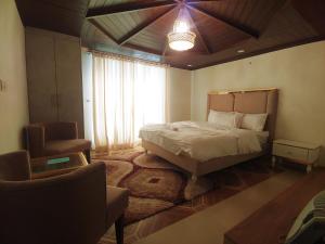 穆里Himalaya Villa's的卧室配有床、椅子和窗户。