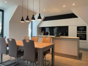 克诺克－海斯特Logie De Terp的厨房以及带木桌和椅子的用餐室。