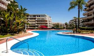 马贝拉Apartamento en Marbella junto a campos de golf的一座带大楼的度假村内的游泳池