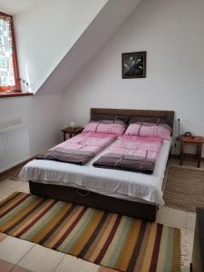 KővágótőttősTótvár lovas szálláshely的一间卧室配有一张粉红色床单。