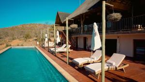 威尔吉旺登禁猎区Shibula Solar Safari Big 5 Lodge的一个带椅子的甲板和一个游泳池