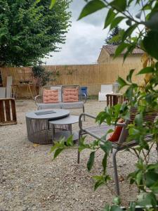 蒙布舍叙尔雅布龙Le studio d'Alexandre - Terrasse et Parking -的庭院配有两把椅子、一张桌子和一张长凳
