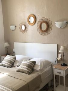 圣马迪拉莫Maison au bord de mer的卧室配有一张白色床,墙上挂有两面镜子