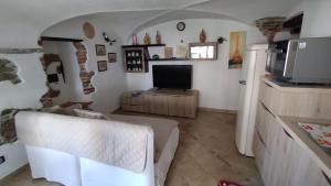 阿伦扎诺Dal Pescatore的带沙发和电视的客厅以及厨房。