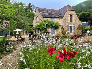 Saint-CybranetEsparoutis的一座房子,前面有一个种着鲜花的花园