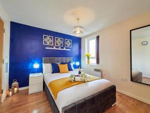 考文垂Beauchamp Suite in Coventry City Centre for Contractors Professionals Tourists Relocators Students and Family的一间卧室设有一张蓝色墙壁的大床