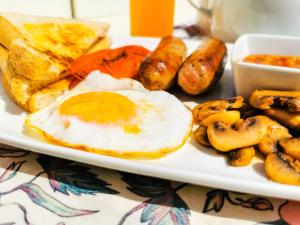 贝拉贝拉Genesis Guesthouze的包括鸡蛋香肠和烤面包的早餐食品