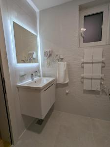 弗尔尼亚奇卡矿泉镇Vila Simfonija的白色的浴室设有水槽和镜子