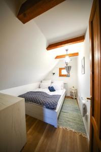 Egy Csipet Csoda Vendégház a Balaton fővárosánál的卧室配有白色墙壁和木地板。