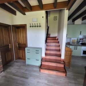 ArboleyaLa puerta de Fredo的铺有木地板的客房的楼梯和厨房