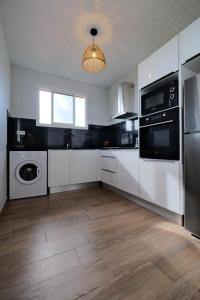 DucosRésidence Terre et Passion的厨房配有白色橱柜、洗衣机和烘干机