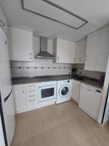 迈阿密普拉特亚Apartamento en Miami Platja - Tarragona的厨房配有白色橱柜、洗衣机和烘干机