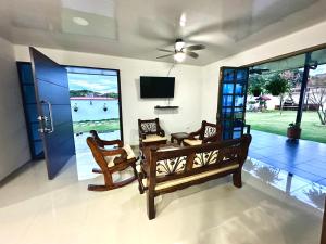里韦拉Villa Pangara的客厅配有桌椅和电视。