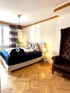 维也纳Center Apartment with 360° Rooftop的一间卧室配有一张床、一张沙发和一把椅子