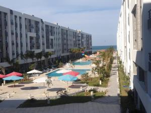 赫尔格达Direct Sea & Pool View FANADIR BAY的享有带游泳池和遮阳伞的度假村景色