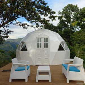 科科尔纳Glamping Rio Melcocho的白色圆顶帐篷配有两把椅子和一张桌子