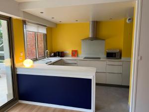 勒图凯-巴黎普拉日O2的厨房设有黄色的墙壁和蓝色的台面