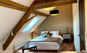 拉旺泽诺Le Gîte de la Grange的阁楼上的卧室配有一张大床