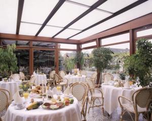 伯格奥夫费马恩哈瑟尔巴特酒店的一间设有白色桌椅和窗户的用餐室