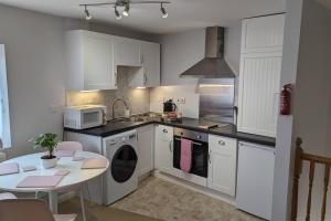 牛津Turtle Dove Apartment的厨房配有白色橱柜、桌子和微波炉