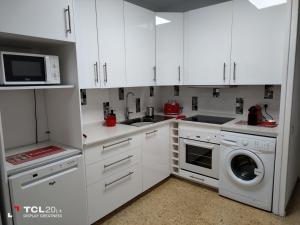 马斯帕洛马斯Casa Maya的厨房配有白色橱柜、洗衣机和烘干机