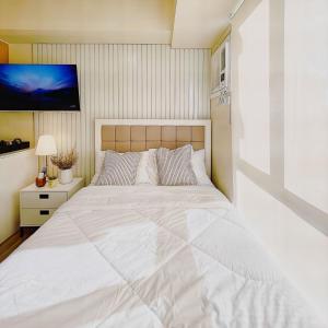 宿务Cebu City Scape at Cebu IT Park的卧室配有一张白色大床和电视。