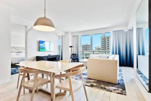 劳德代尔堡Oceanview Luxury, Resort Access, Sleeps 6 2BR 2BA - Vista Mar by HomeStakes的用餐室以及带桌椅的起居室。