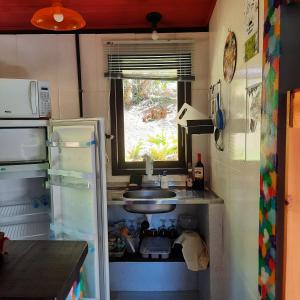 圣佩德罗塞拉Suítes Casinha do Alto da Bocaina的一间带水槽和冰箱的小厨房