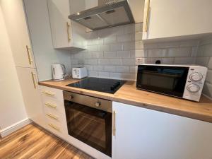 利物浦Liverpool Cherry House - 4 Bedrooms的厨房配有微波炉和炉灶。 顶部烤箱