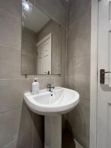 利物浦Liverpool Cherry House - 4 Bedrooms的浴室设有白色水槽和镜子