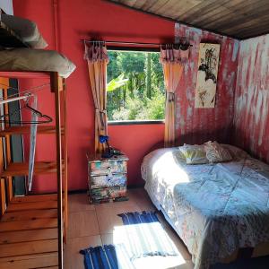 圣佩德罗塞拉Suítes Casinha do Alto da Bocaina的一间卧室设有一张床和一个窗口