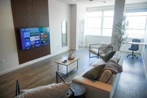 巴吞鲁日Entire High-Rise Apartment - 2BD的客厅配有2张沙发和1台平面电视