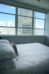 巴吞鲁日Entire High-Rise Apartment - 2BD的一间配备有白色床的卧室,享有城市美景。