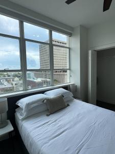 巴吞鲁日Stylish Downtown High-Rise - 2BD的配有大窗户的客房内的白色床
