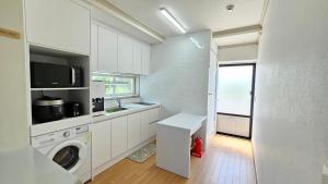 济州市Someday Jeju的白色的厨房配有洗衣机和窗户。