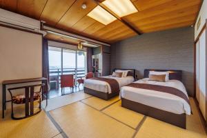 佐渡市Sado Resort Hotel Azuma的酒店客房设有两张床和一个阳台。