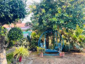 Ban Si WichaBan Aob Maiy(บ้านโอบไม้)的绿树成荫的花园中的蓝色门