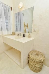 瓦塔穆Cacuki Boutique House的一间带水槽、镜子和凳子的浴室