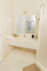 瓦塔穆Cacuki Boutique House的白色的浴室设有水槽和镜子