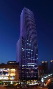 上海上海龙之梦万丽酒店的一座高大的建筑,晚上有紫色的灯光