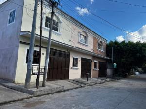 ChalchuapaChalchuapa, Santa Ana La Casa de Sussy, El Salvador的街上的白色建筑,有棕色门
