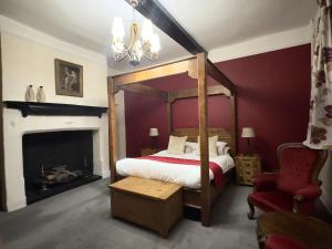 迪斯Scole Inn Hotel的一间卧室设有一张天蓬床和一个壁炉