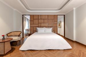 河内La Siesta Classic Hang Thung的卧室配有一张白色的大床和一张桌子